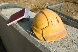 Cracked hard hat of a construction worker who needs help of a workers' compensation attorney