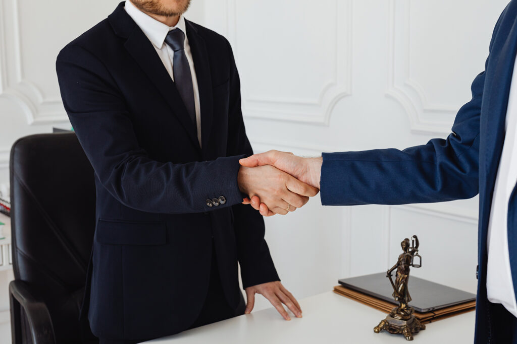 A car wreck client shaking hands with the attorney of an accidents law firm after a meeting